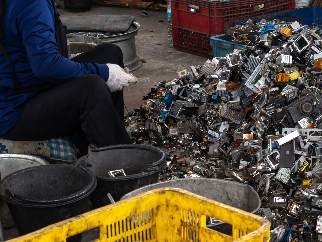 A Beartown Recycling worker in gloves standing in front of scrap at the yard