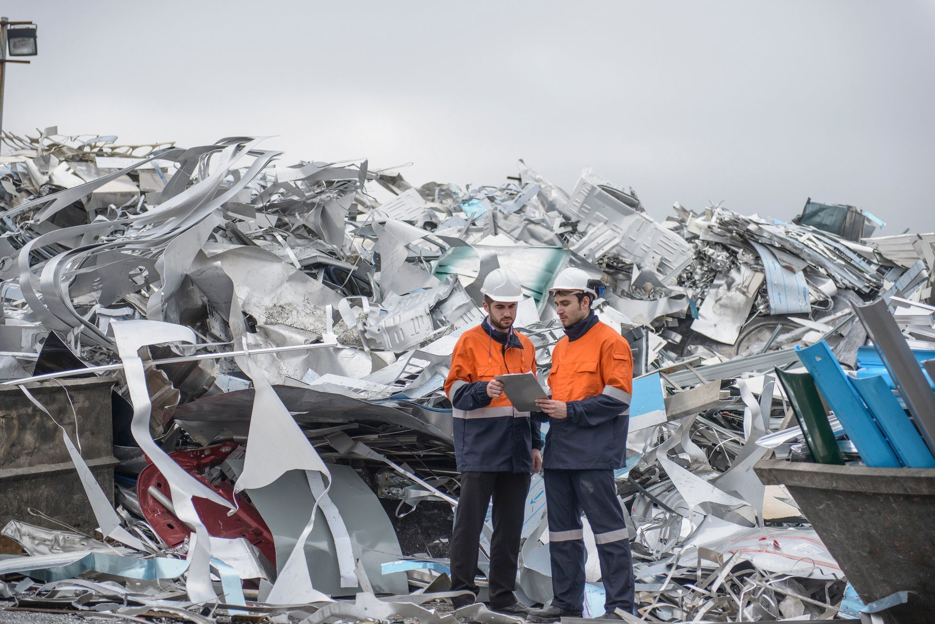 Two Beartown Recycling staff in hi-vis gear reviewing a load of scrap metal